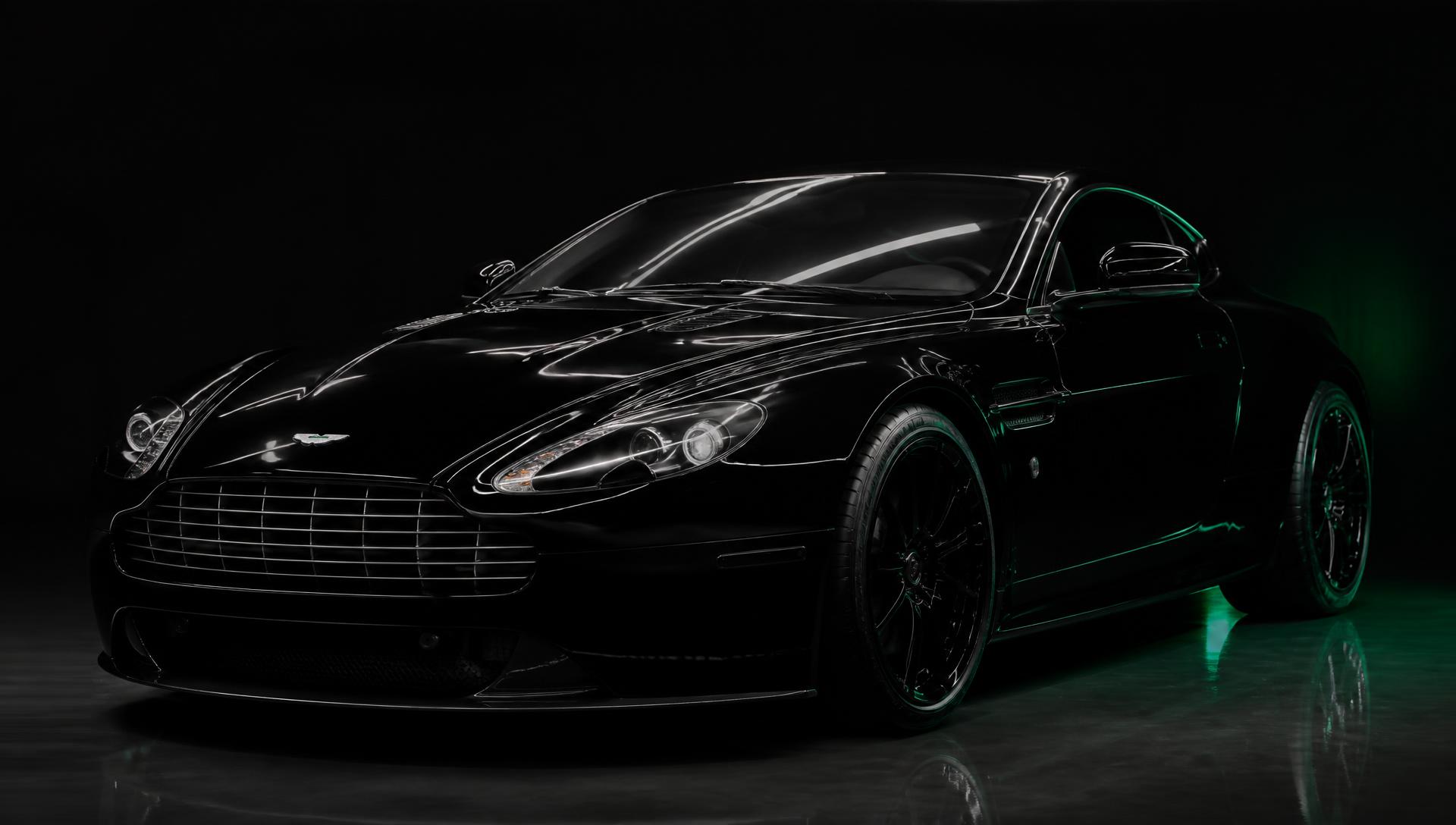Freshly detailed black luxury sports car in a dark studio